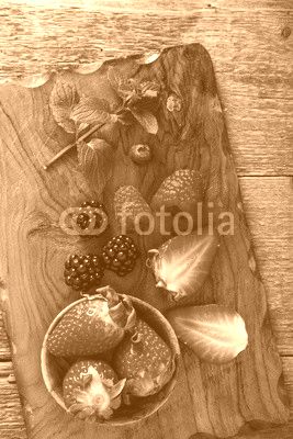 strawberry and berries on wooden cutting board