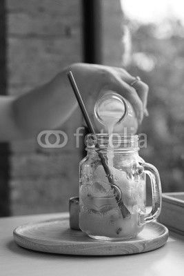 Woman pouring Passion fruit juice in the jar of passion fruit juice ice cube.