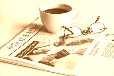 Newspaper with eyeglasses on white table