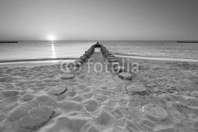lange hölzerne Buhnen am Strand, Sonnenuntergang am Meer