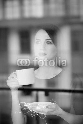 Beautiful redhead woman with cup of coffee or cappuccino near a
