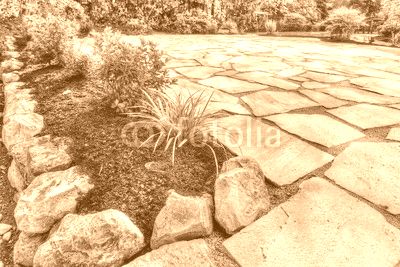 Completed flower beds around new stone patio with plants in place