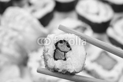 Sushi set. Chopsticks with portion of sushi