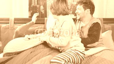 Family having pillow fight in bed slow motion