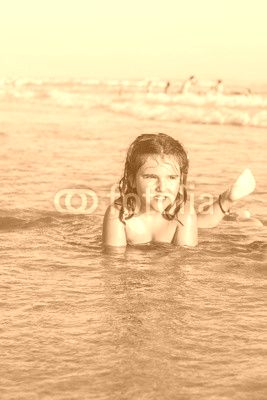 Girl swiming and playing in the seashore of the beach