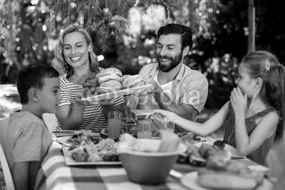 Happy family having meal in yard 