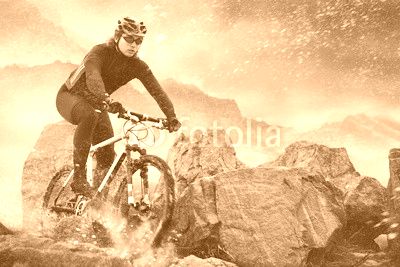 Cyclist climbing on a rock