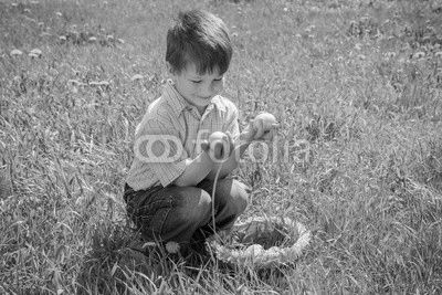 little kid with colorful easter eggs on green lawn