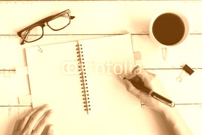 Cup of coffee with notebook and copy space on white wooden desk