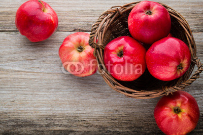 Ripe red apples on wooden background.