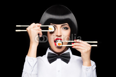 Beautiful woman eating sushi with chopsticks