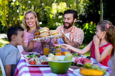 Happy family having meal in yard 
