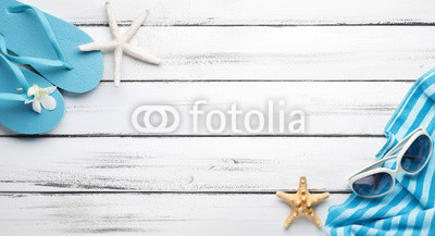 Towel and beach slippers on wood..