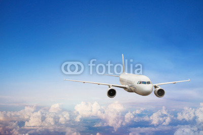 travel by plane, international flight, airplane flying in blue sky above the clouds