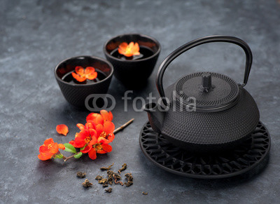 Black iron asian style teapot and cups green tea and flowers