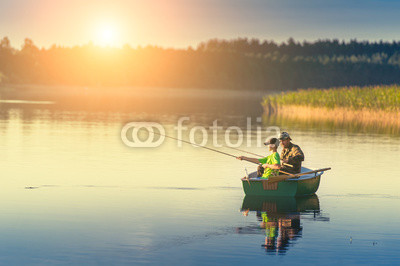father and son catch fish from a boat at sunset