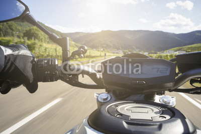 Motorradfahrer fährt auf Straße im Sommer