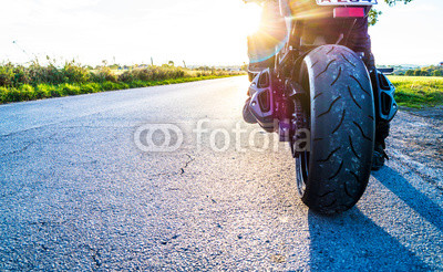 Motorrad fahren auf Landstrasse im Sonnenlicht
