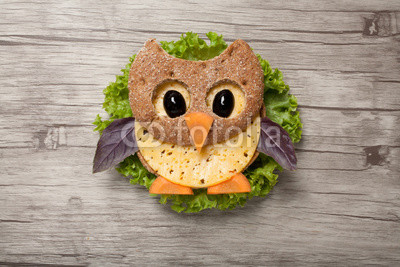 Owl made of bread and cheese on wooden background
