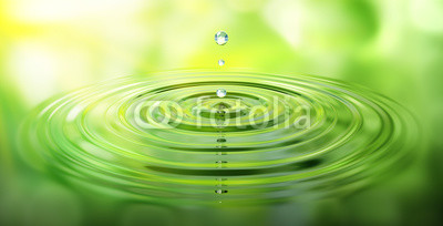 Wassertropfen und Wellen mit grüner Spiegelung