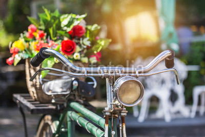 close up vintage bicycle with bouquet flowers in basket in vintage tone style