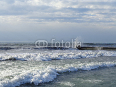 Winter storm at the Black sea, waves splashing on the pier