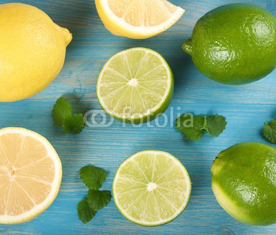 limes and lemons on a wooden background