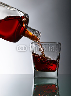 bottle and glass of whiskey on a glass table