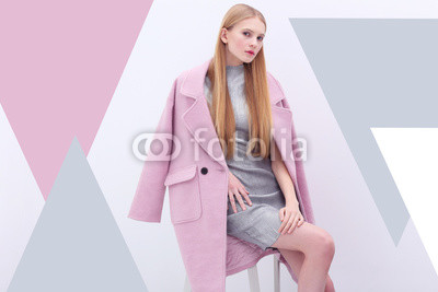 Young elegant woman in trendy pink coat.