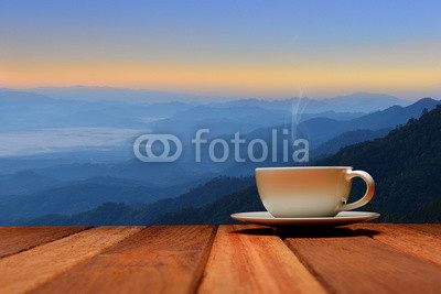 Morning cup of coffee or tea with mountain background at sunrise
