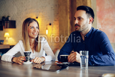 Young businesswoman and man on coffee break in cafe