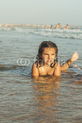 Girl swiming and playing in the seashore of the beach