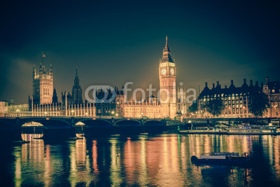 Iconic view Westminster with Big Ben, Houses of Parliament and Thames at Victoria Embankment lit up at night.