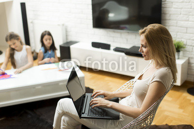 Mother and daughter in the room on the laptop at home