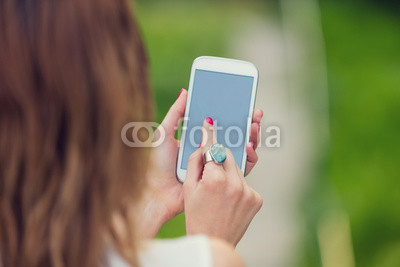 Girl using cellphone outdoors.
