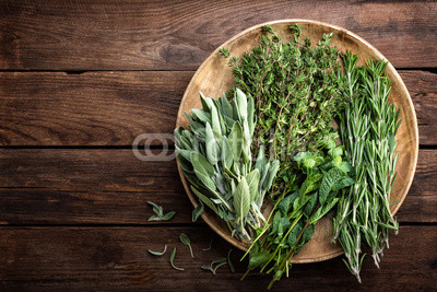 various fresh herbs, rosemary, thyme, mint and sage on wooden background