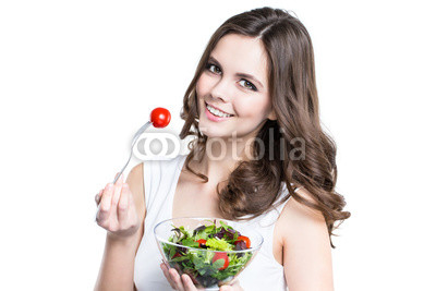 Close-up of pretty girl eating fresh vegetable salad.