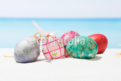 Easter on tropical beach background. Eggs on the white sand. Vacation and travel concept