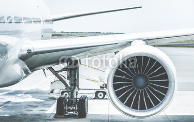 Detail of airplane engine wing at terminal gate before takeoff - Wanderlust travel concept around the world with air plane at international airport - Retro contrast filter with light blue color tones