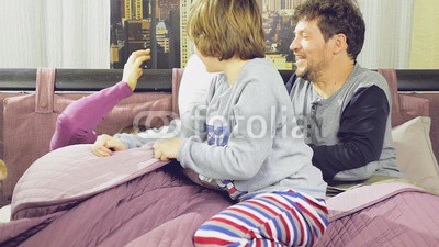 Family having pillow fight in bed slow motion