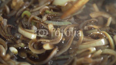 Chef fryes onion in a hot frying pan, vegetables are cooked, meals with vegetables