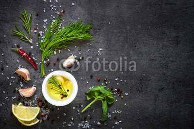Selection of spices herbs and greens. Top view black background. Cooking ingredients