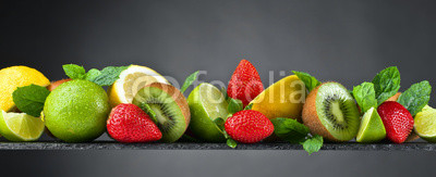 Ripe juicy fruits and peppermint with water drops