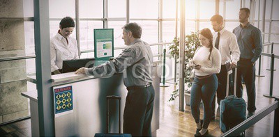 People waiting in queue at airplane counter