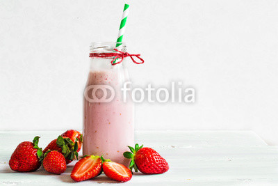 Strawberry smoothie or milkshake in a bottle with straw