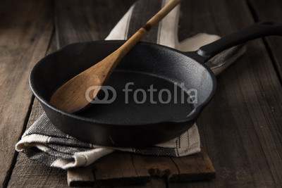 Cast iron frying pan on country rustic wooden/timber background