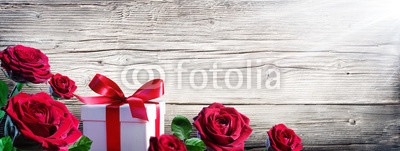 Gift Box And Roses On Vintage Wooden Background
