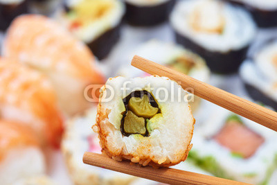 Sushi set. Chopsticks with portion of sushi