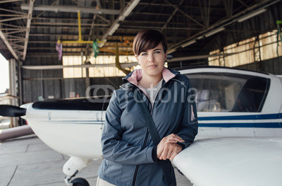 Female pilot posing in the hangar