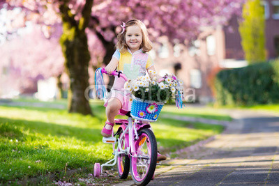 Little girl riding a bike. Child on bicycle.